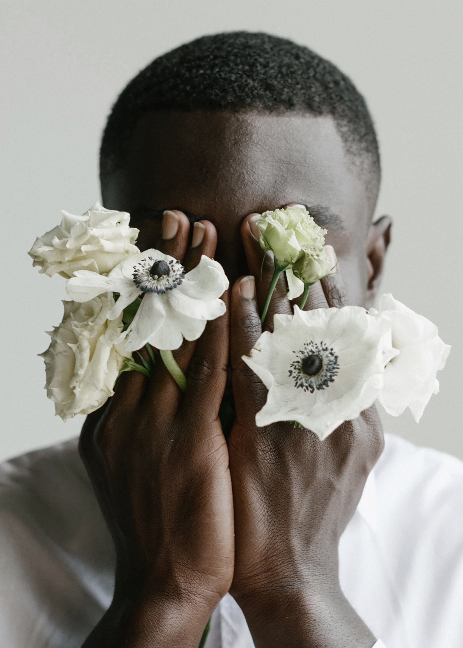 woman holding white flowers in hands in front of face