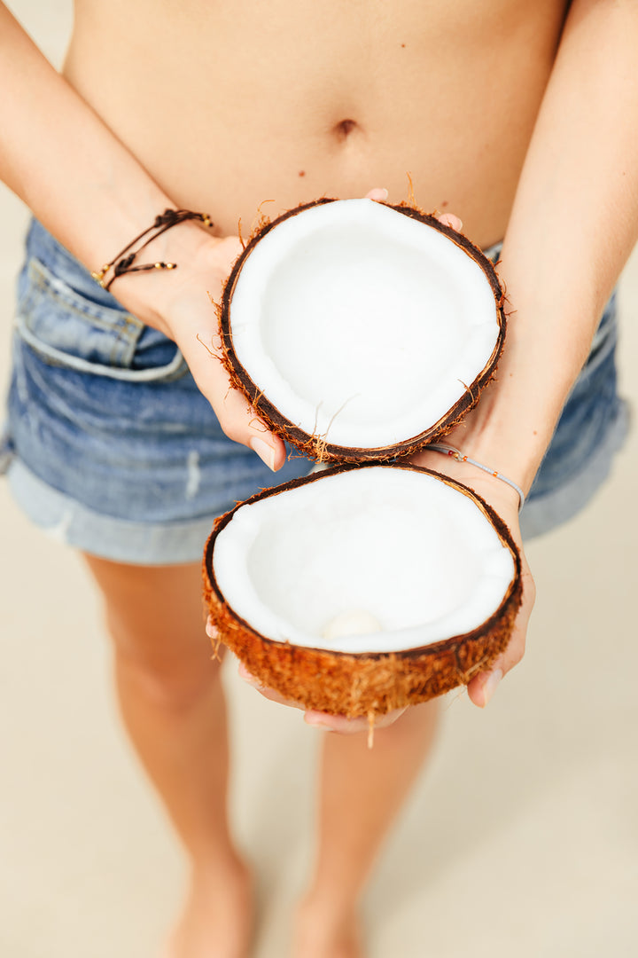 Hands Holding Two Coconut Halves