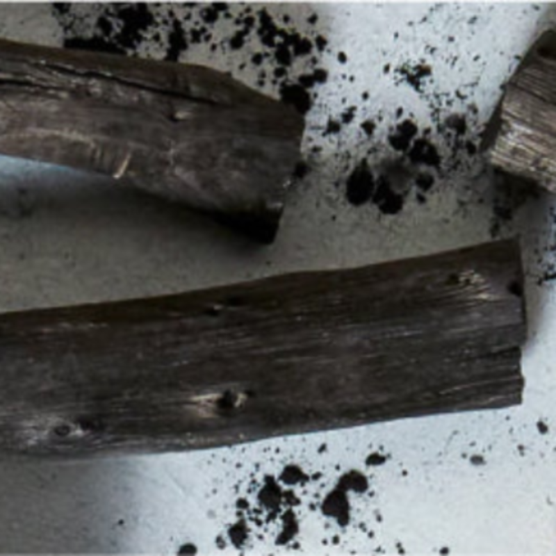 Wooden sticks on a white surface with black specks