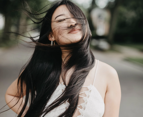 woman smiling with hair blowing in wind