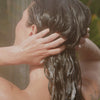 woman washing hair and using sulfate free paraben free Raw Sugar Shampoo