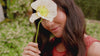 video of woman holding flower and smiling