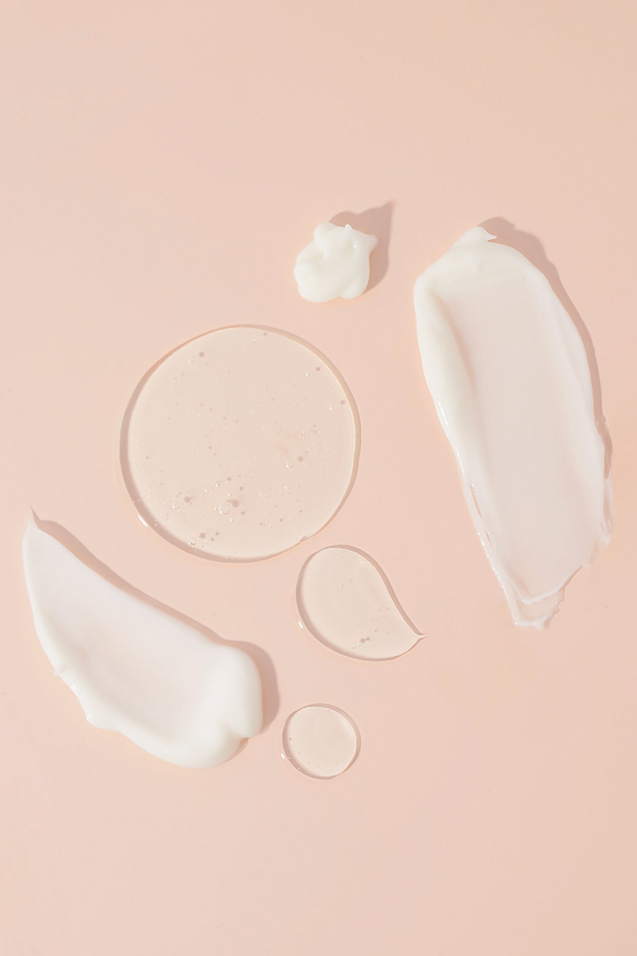 shampoo and conditioner goop on light pink background