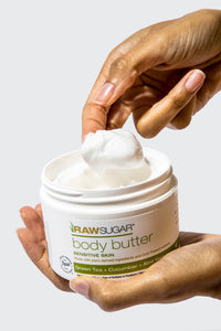 hand scooping body butter out of jar
