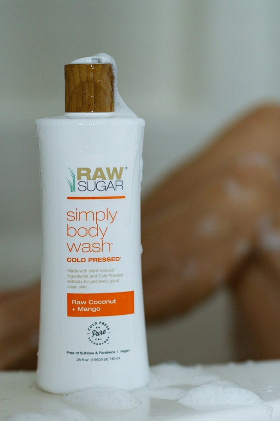 Simply Body Wash | Raw Coconut + Mango bottle with white lather on bottle and table