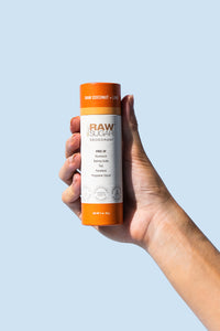 Hand holding tube of Raw Coconut + Lime Deodorant