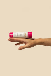 Tube of Watermelon+ Hibiscus deodorant in eco tube balancing on top of flat hand in the air