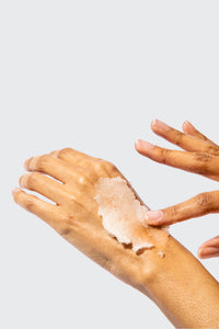 A pair of hands applying scrub to back of one hand