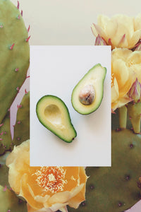 Fresh avocado halves with cactus flower pear plant