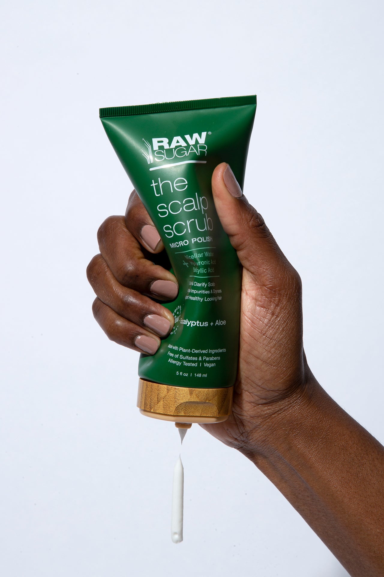 Hand squeezing Raw Sugar Scalp Scrub