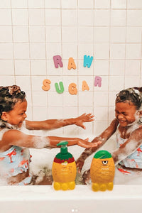 Two Kids in Tub Playing with Two Kids Products in front