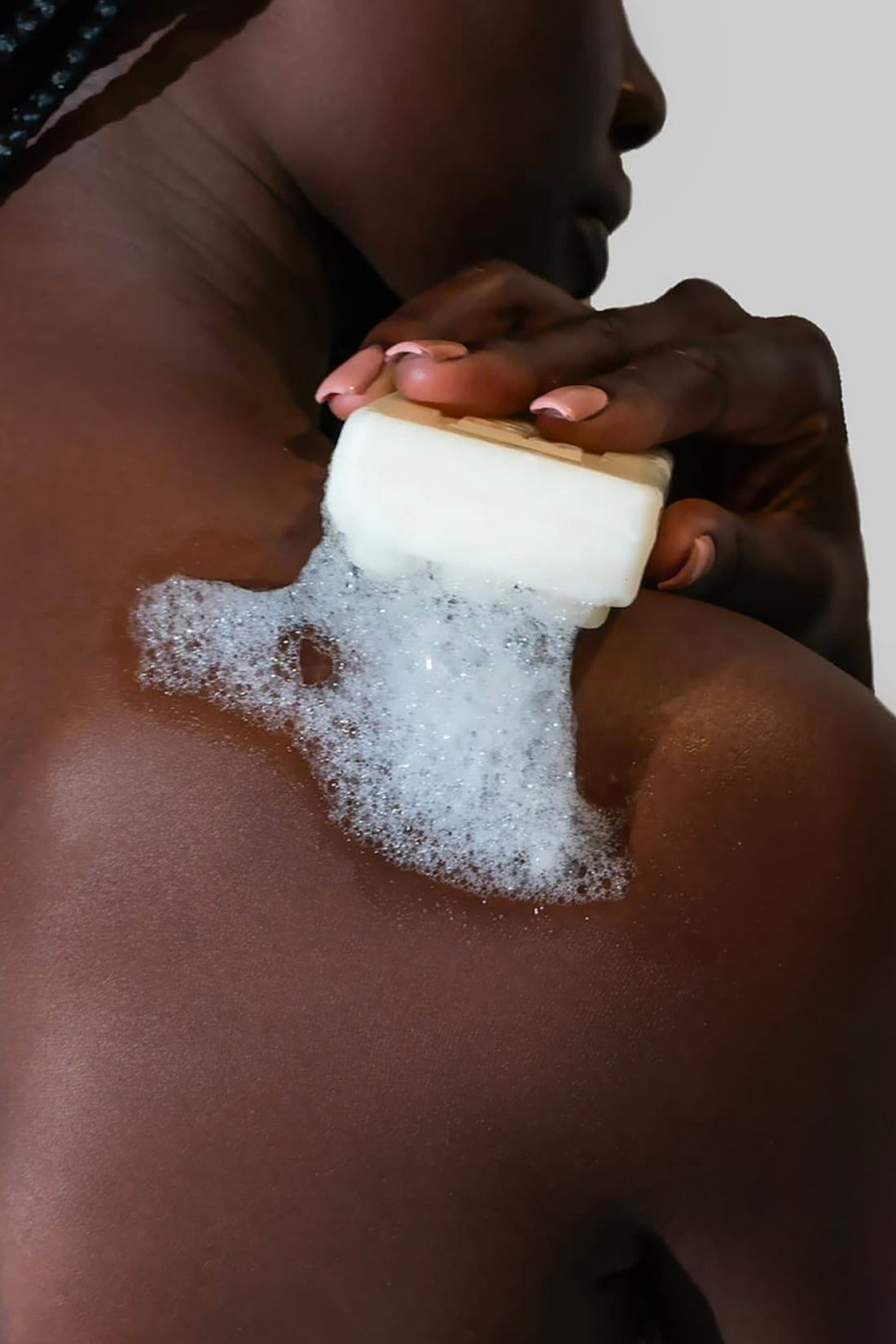 Woman Holding Bar Soap With Suds on Her Shoulder