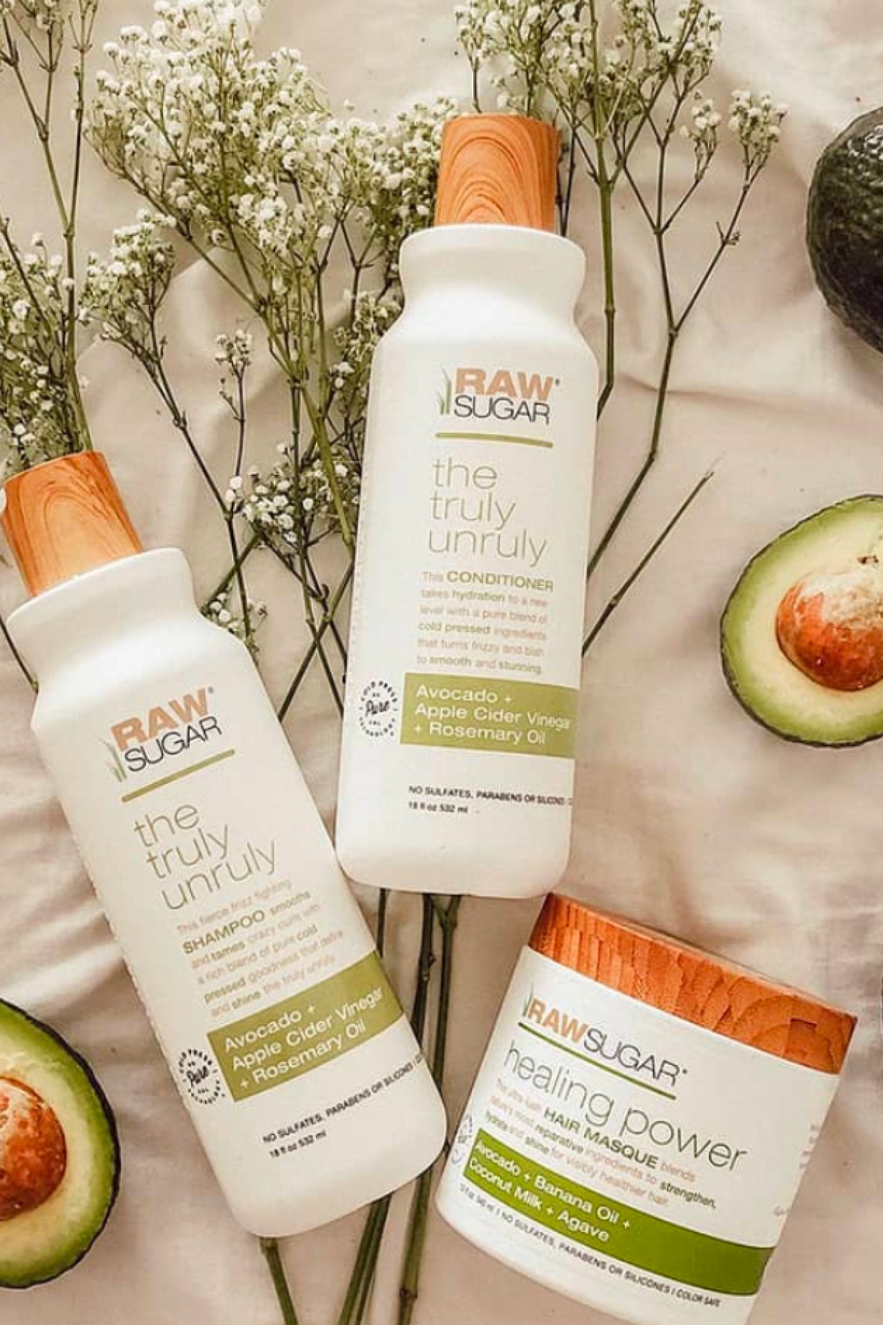 Avocado Hair products against background with avocado and flowers