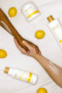 People holding hands with lemons and lemon products on bed