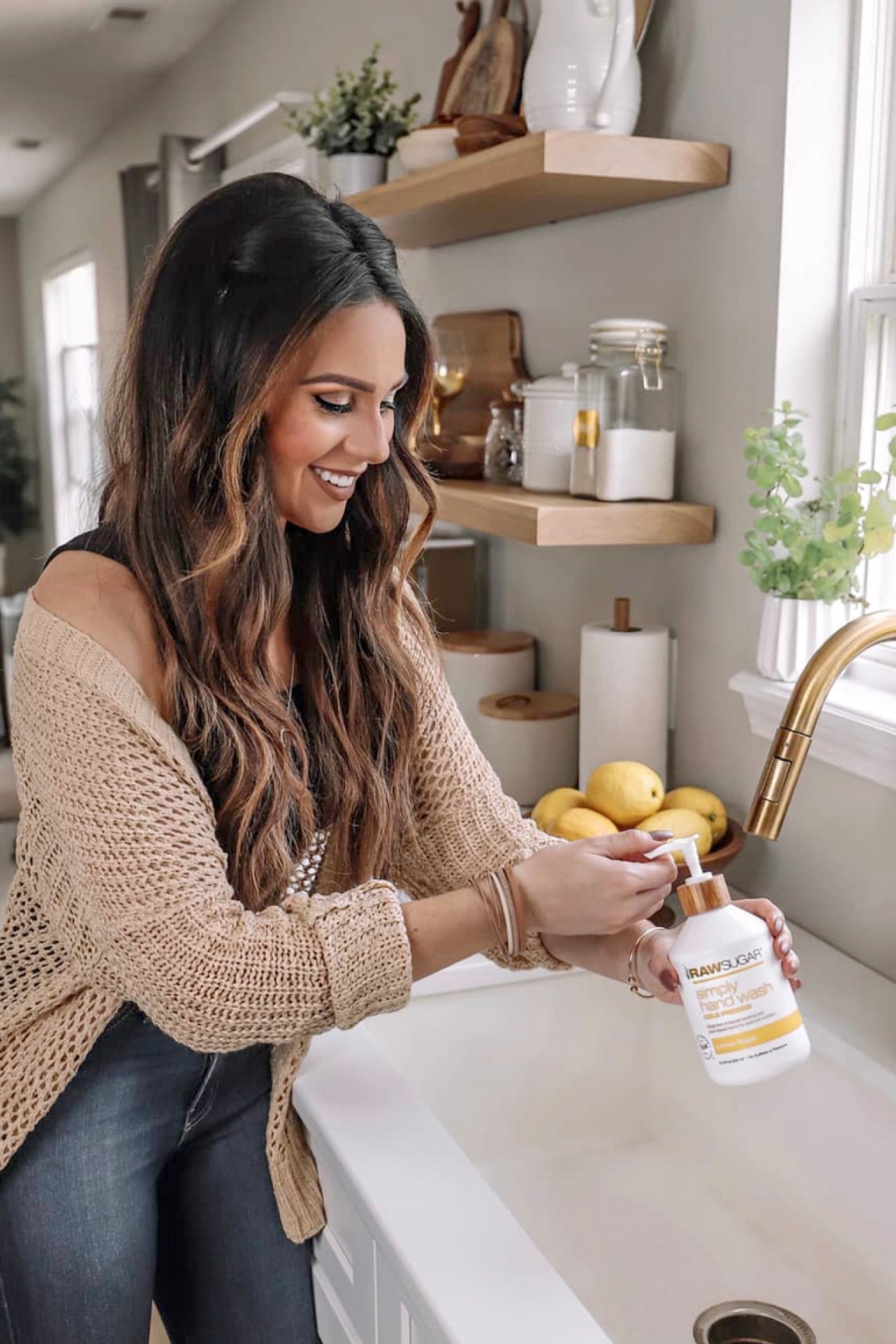 woman at kitchen sink washing her hands with Raw Sugar Lemon Hand Wash