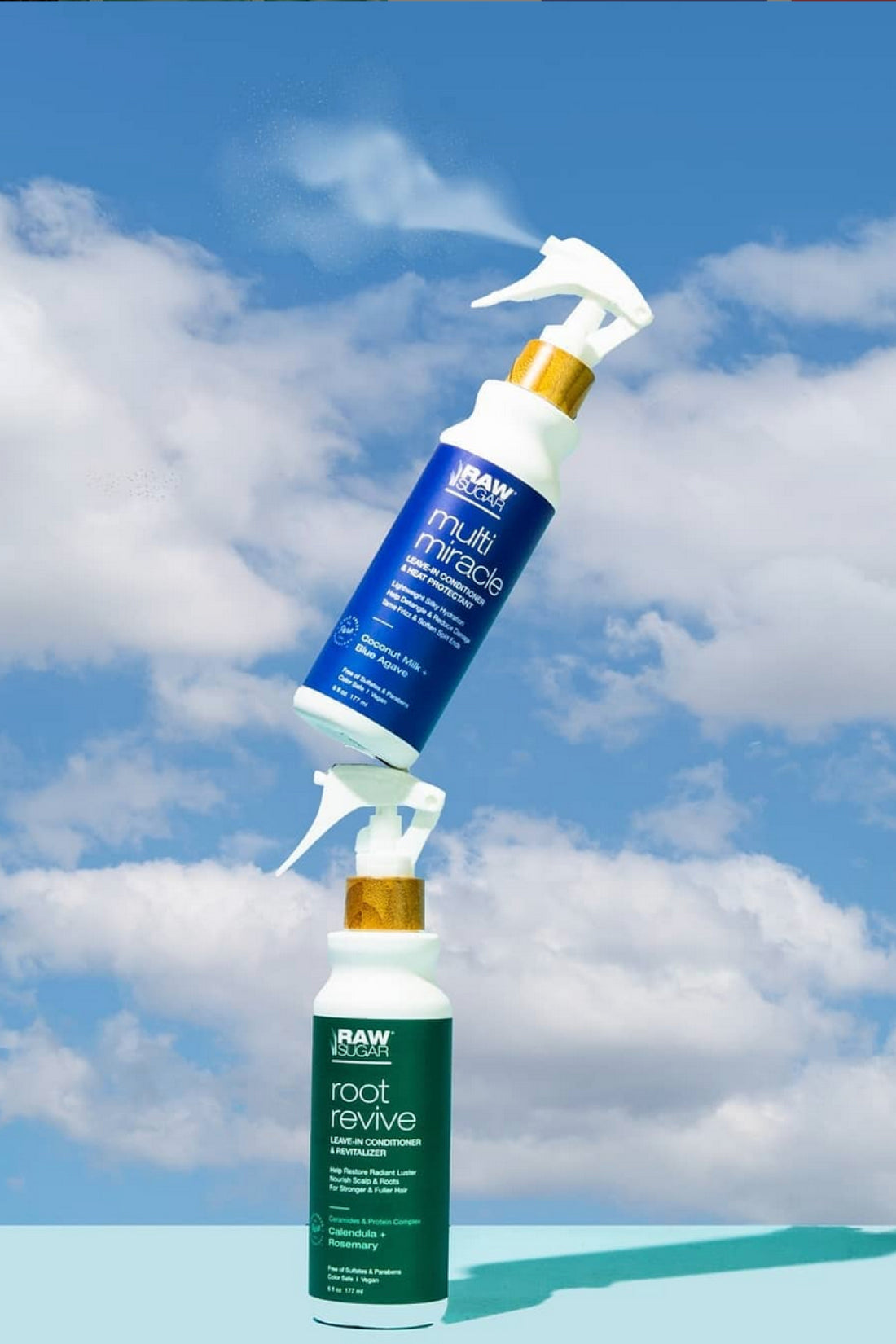 Multi Miracle Spray Resting on Root Rvive Spray in front of blue sky background