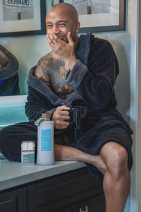 man on sink with body wash and bar soap