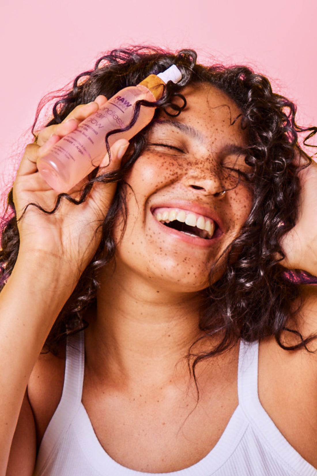 Woman Smiling and Holding Hair Oil