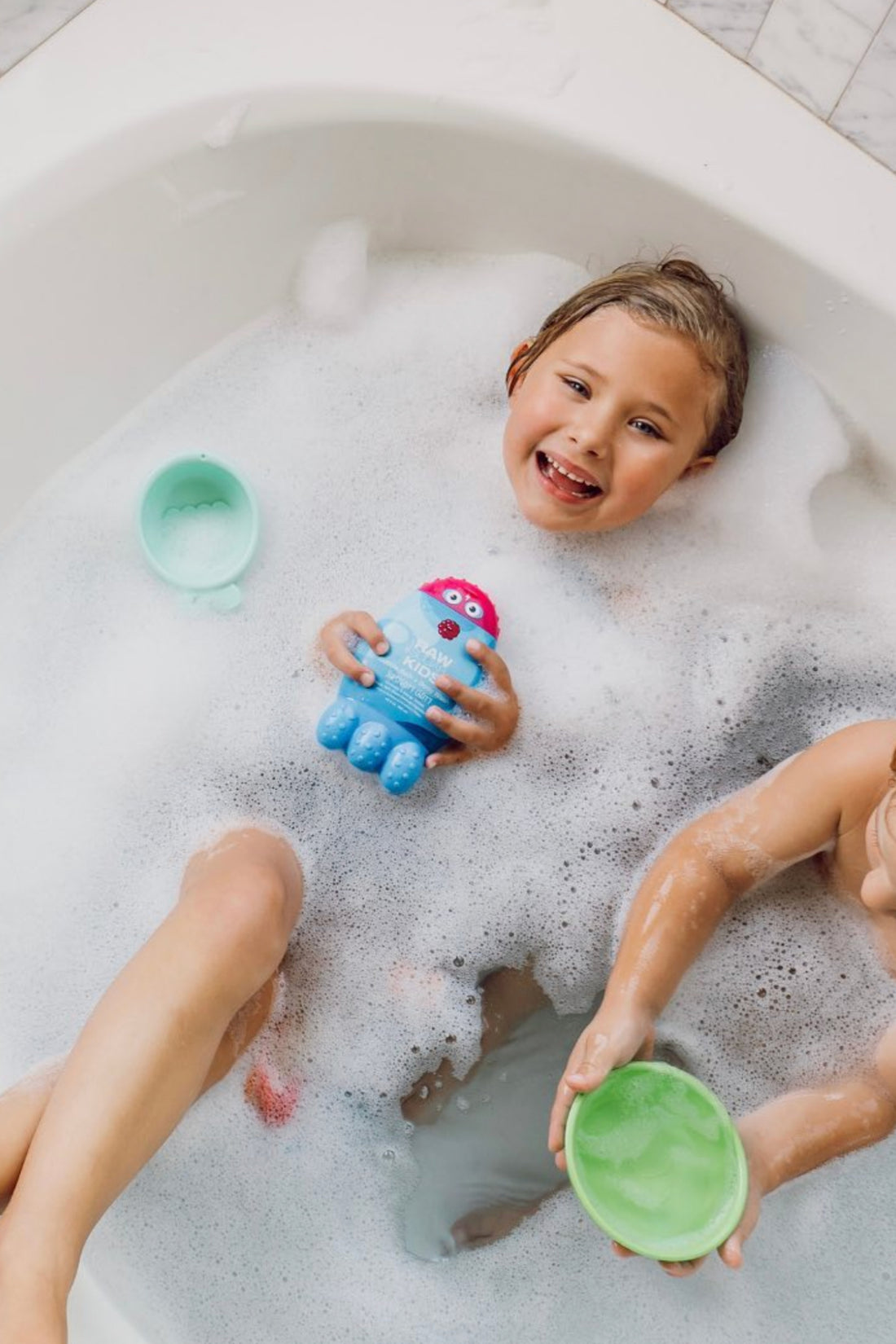 Image of Kids in Tub with Bubbles, One Hoplding Body Wash and Bubble Bath