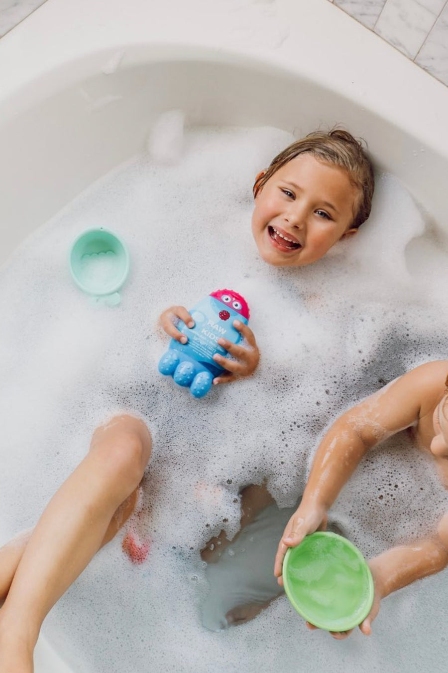 Image of Kids in Tub with Bubbles, One Hoplding Body Wash and Bubble Bath