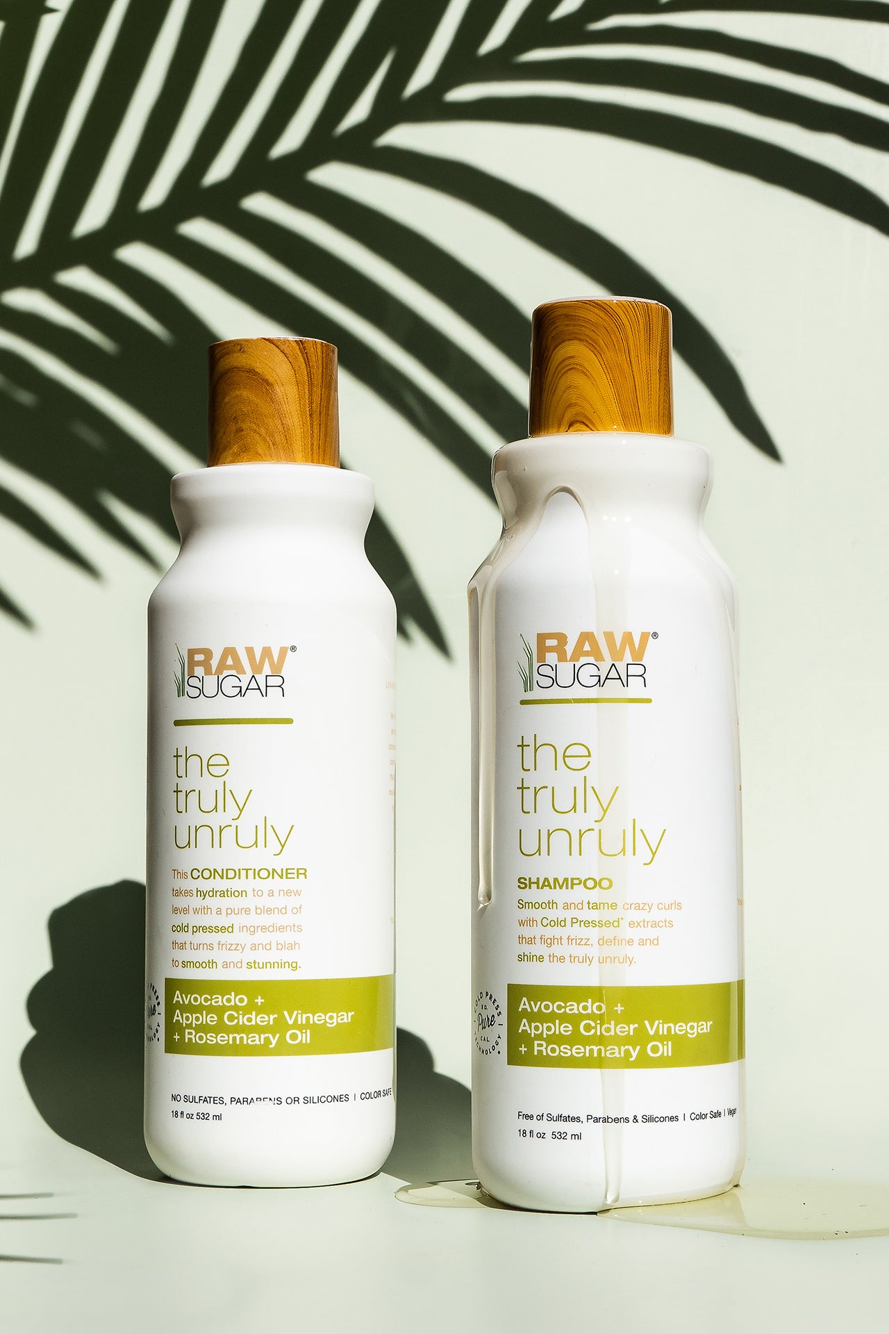 Truly Unruly Conditioner and Shampoo products with palm leaf shadow 