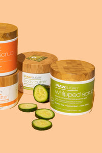 Raw Sugar body butters and scrubs with fresh sliced cucumbers