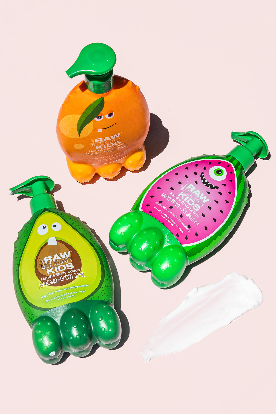 Three Kids Lotions on Light Pink Background with Lotion on Ground