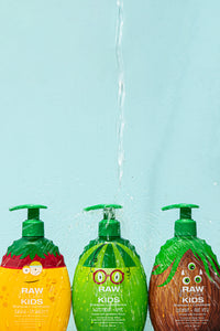 3  Raw Sugar Kids Shampoo Monster bottles with water pouring down on center bottle creating splashing effect over other bottles