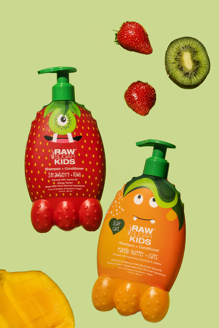 Raw Sugar Kids Monster bottles of Mango Butter + Oats and Strawberry + Kiwi are floating on a light green background with a fresh kiwi slice, strawberries and a slice of mango