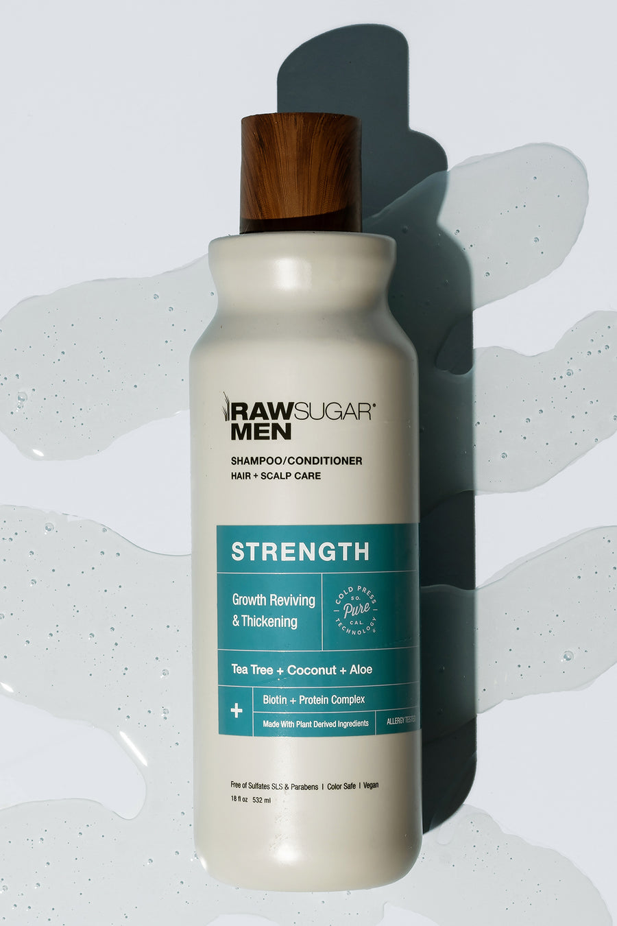 mens strength shampoo and conditioner laying flat with shampoo in background